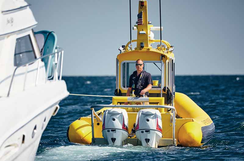 Captain John Bilski towing a large recreational boat as part of Sea Tow's boat towing services.